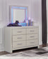 Zyniden Queen Upholstered Panel Headboard with Mirrored Dresser and Chest